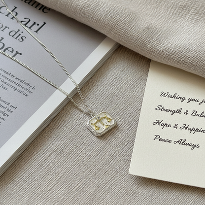 Side view of Libra scales necklace in S925 silver with bicolor gold and silver finish
